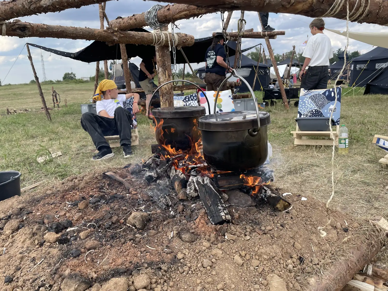 Zwei Töpfe hängen über dem Lagerfeuer