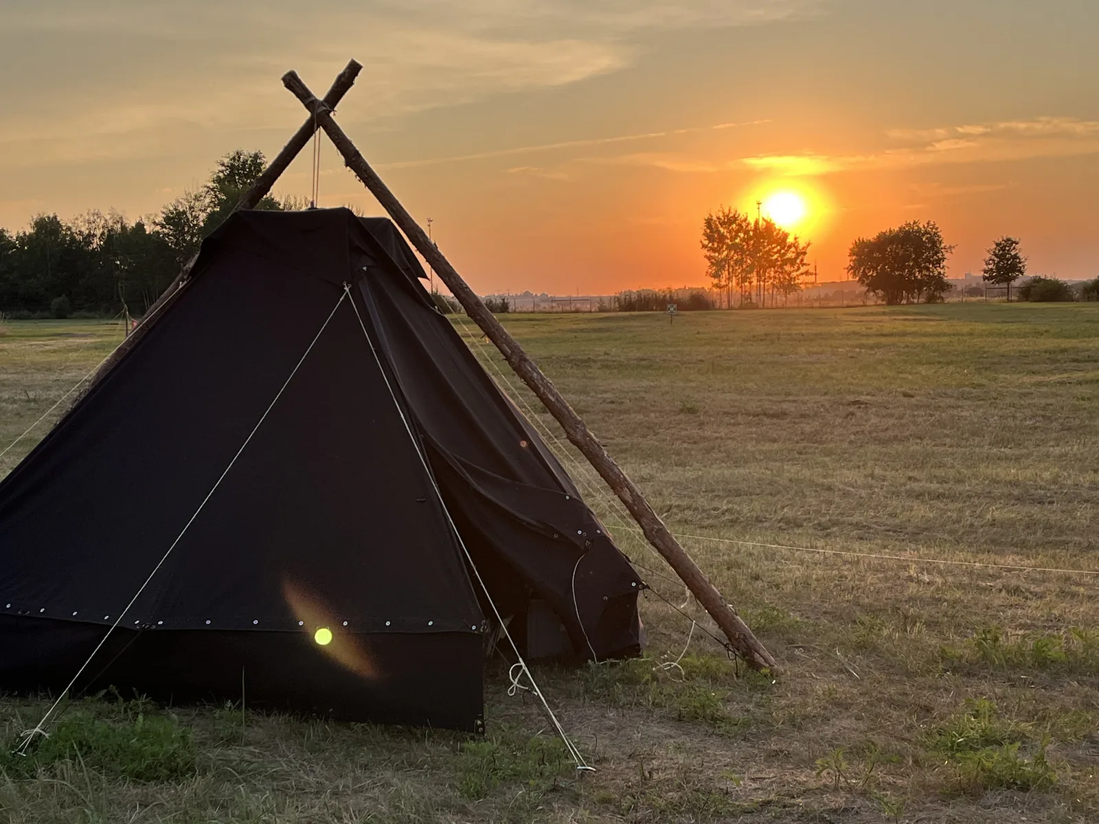 Kohte im Camp, daneben geht die Sonne unter