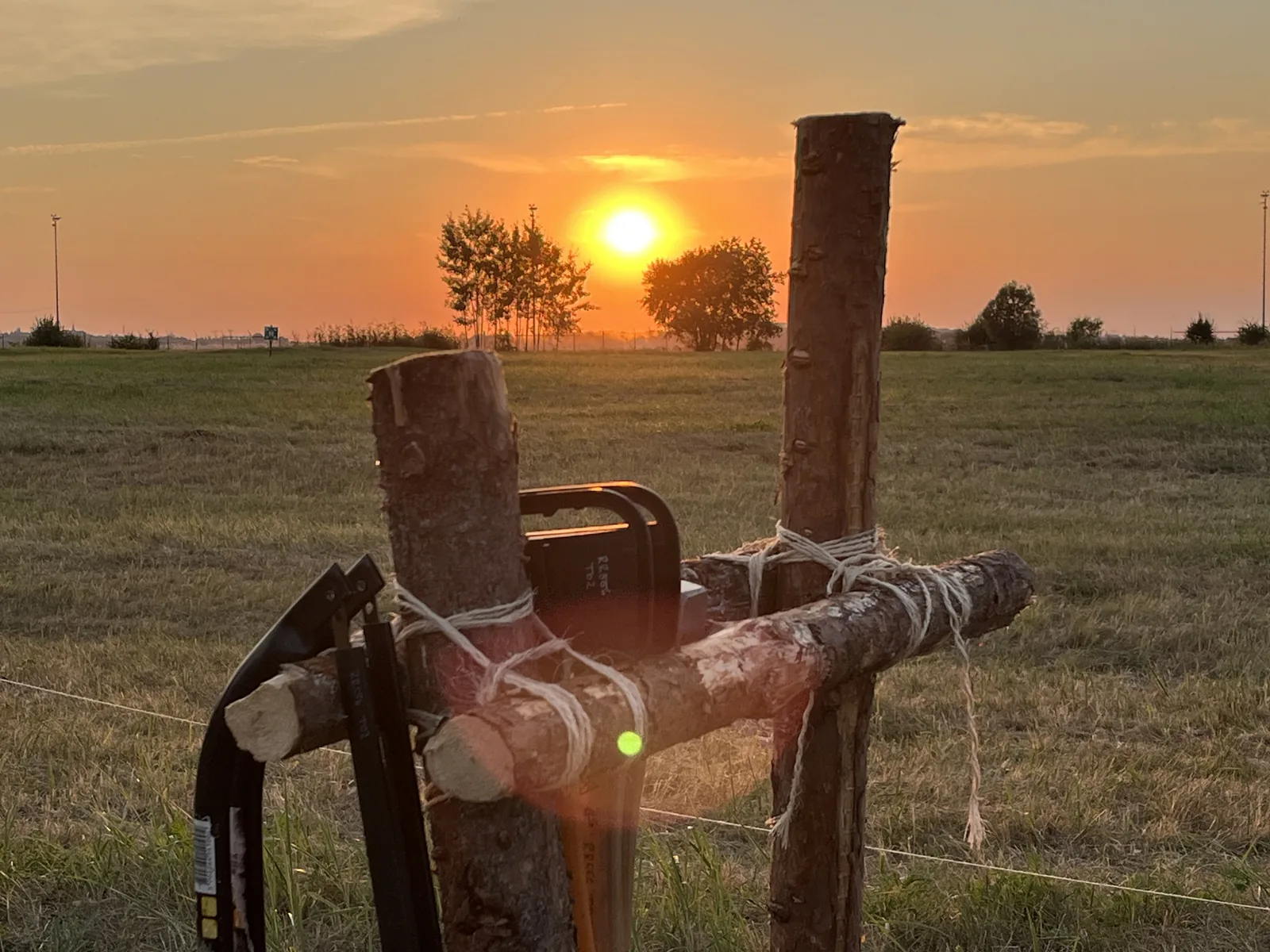 Selbstgebauter Werkzeugständer aus Holz und Seil vor untergehender Sonne